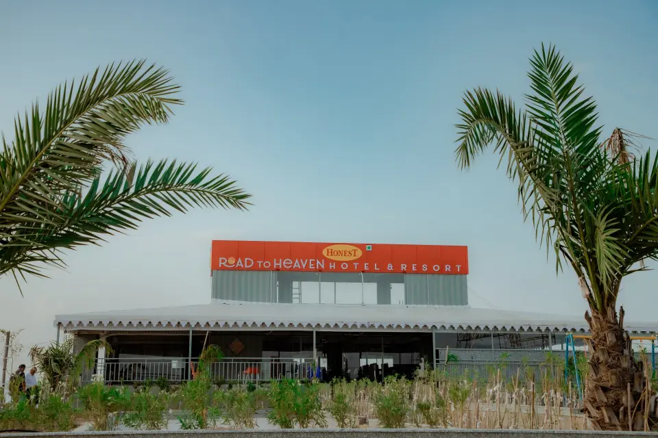 Road to Heaven Hotel & Resort entrance with palm trees under a blue sky